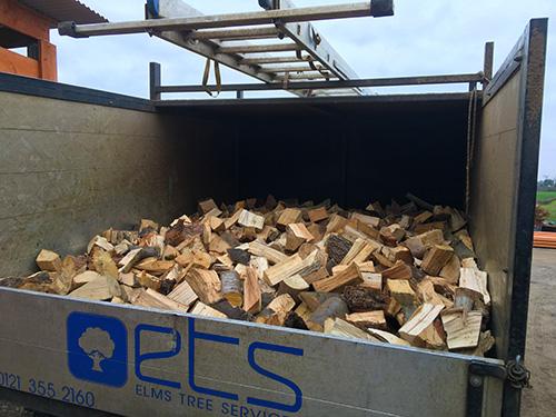 Seasoned firewood stacked in the back of the Elms Tree Services van for delivery across the West Midlands